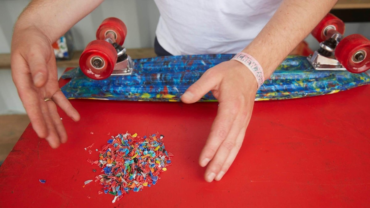 Rood skateboard gemaakt van plastic doppen, met de doppen ook in het zicht vanwege aandacht circulaire economie