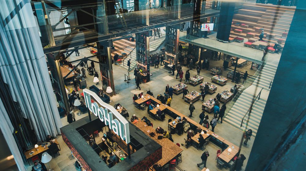 Lochal pand van binnen met mensen, zitplekken en vergaderruimtes