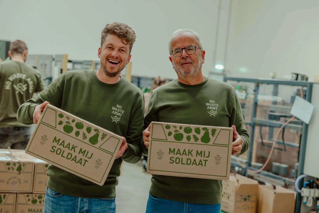 2 mannen van No Waste Army staan met hun productenboxen in de handen